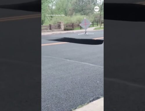 Bystanders watch as large sinkhole swallows portion of Colorado road